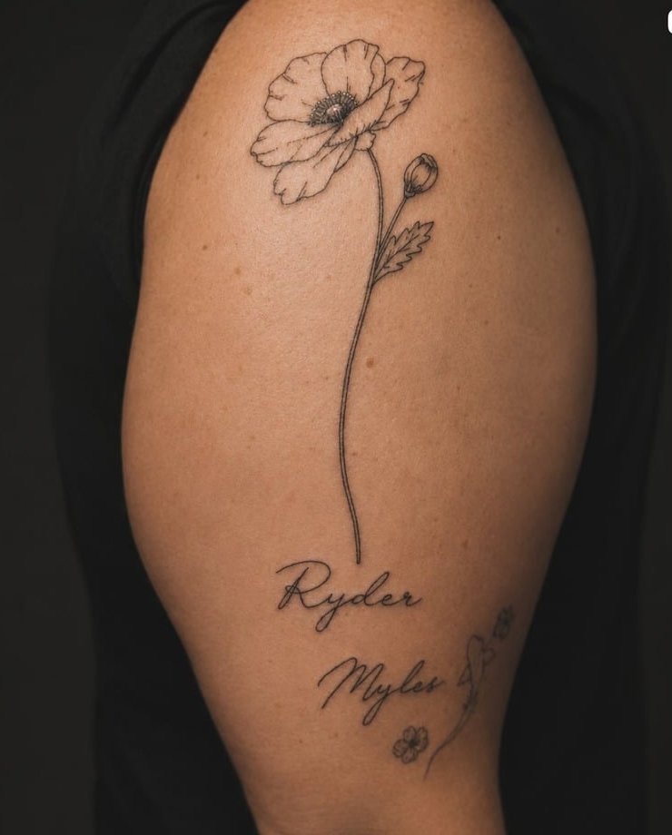 Fine-line poppy flower above two handwritten children's names on an upper arm